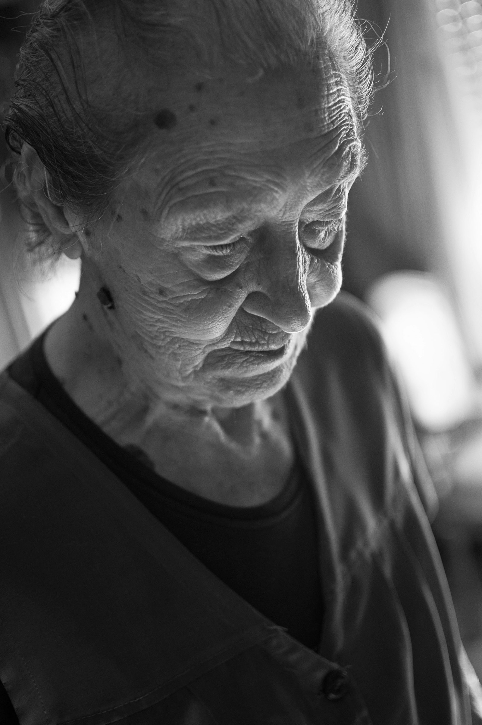 An older woman reading a message on her phone at home